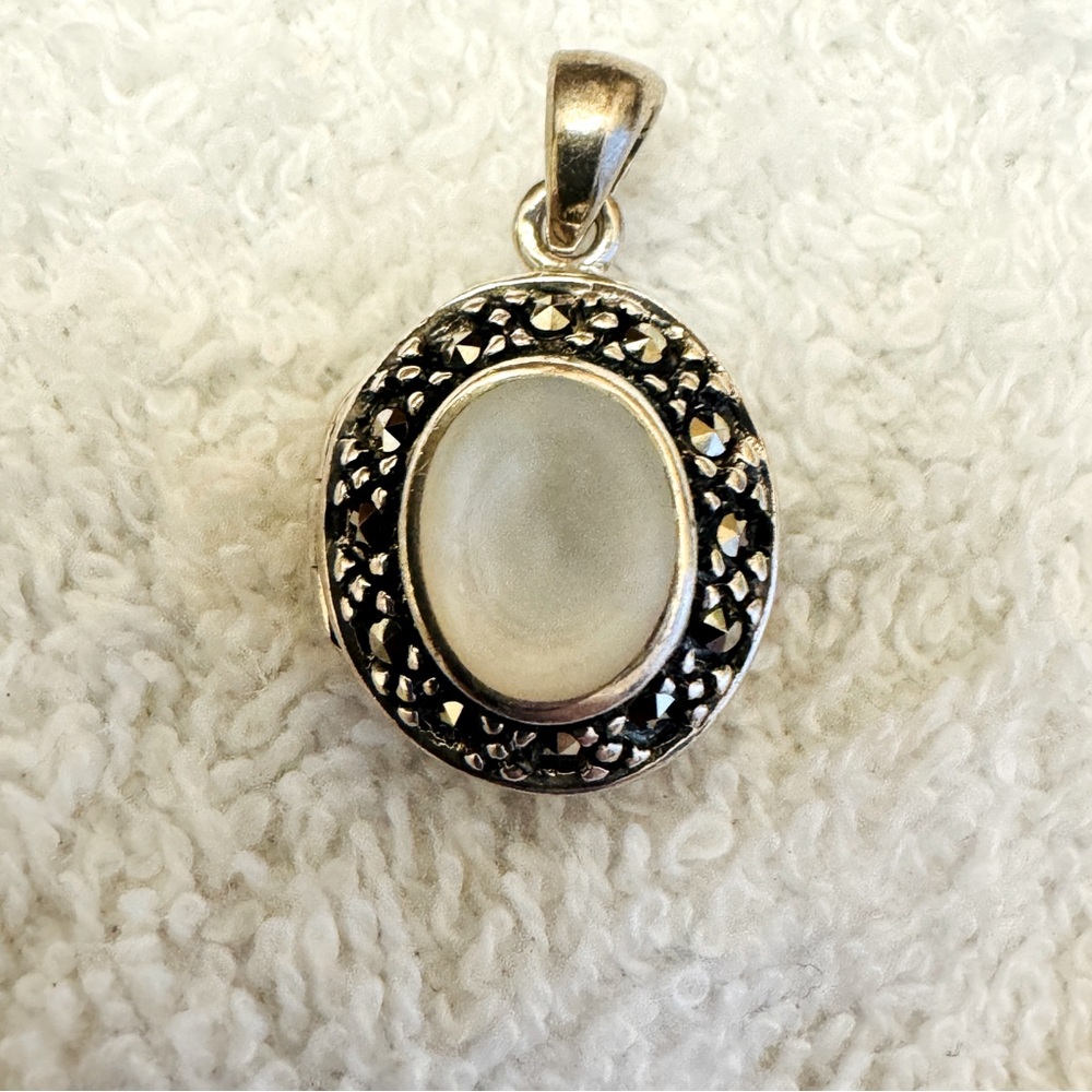 Sterling Silver locket pendant.marcasite stones surrounding Opal gemstone center